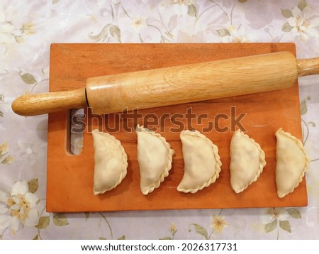 A picture of raw curry puff pastry which are preparing for frying. Curry puff pastry, popular Malaysia bakery.