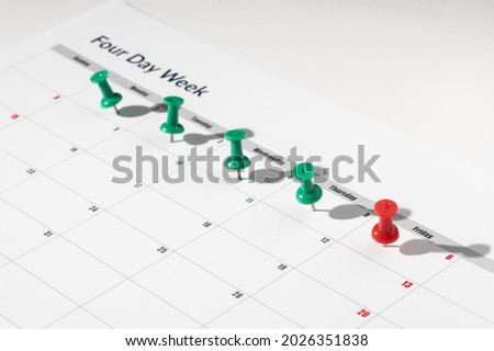 Printed calendar for a 4 day working week showing weekend days in red in new approach to productivity Royalty-Free Stock Photo #2026351838