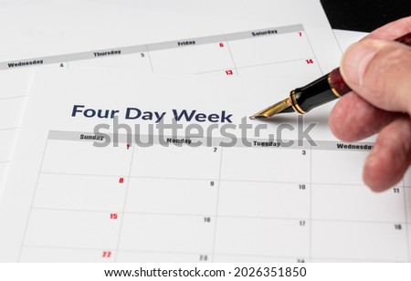 Printed calendar for a 4 day working week showing weekend days in red in new approach to productivity Royalty-Free Stock Photo #2026351850
