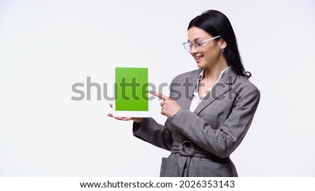 Smiling businesswoman pointing at digital tablet with chroma key isolated on white