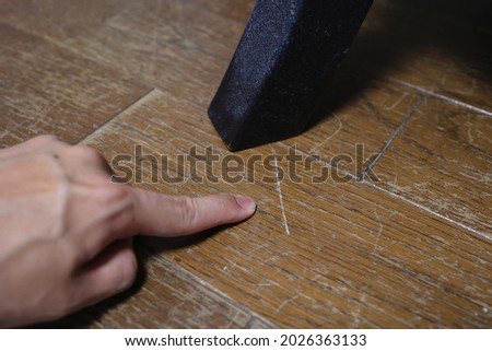 There are numerous scratches on the floor, scraped by the chair. Royalty-Free Stock Photo #2026363133