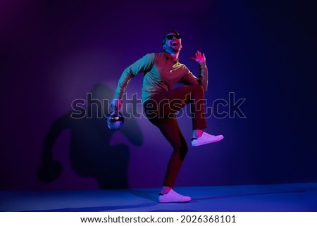 Full length body size photo man in sunglass dancing on discotheque keeping disco ball isolated on violet color background