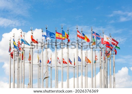 Group of flags of European countries waves against blue sky with few clouds. Global business and communications. Sports competition. International relations theme.