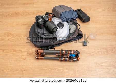 Backpack with photography supplies. Digital camera, cobra flash, extra battery, foldable carbon type, white diffuser.