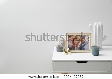 Framed photo of happy couple and candles on white table indoors. Space for text