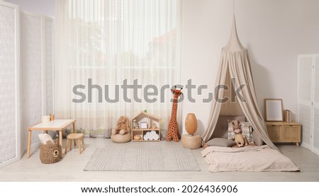 Cozy kids room with play tent, toys and comfortable floor bed. Montessori interior Royalty-Free Stock Photo #2026436906