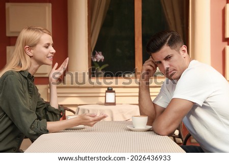 Man having boring date with talkative woman in outdoor cafe Royalty-Free Stock Photo #2026436933