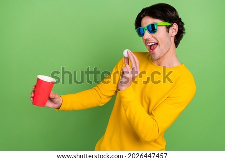 Photo portrait man wearing sunglass playing beer pong at party isolated pastel green color background