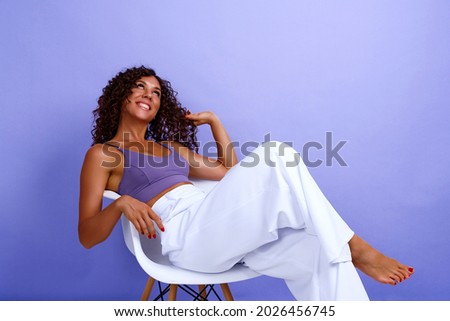 snapshot of happy cheerful expressive and satisfied black african american woman. woman sitting in a fashionable armchair