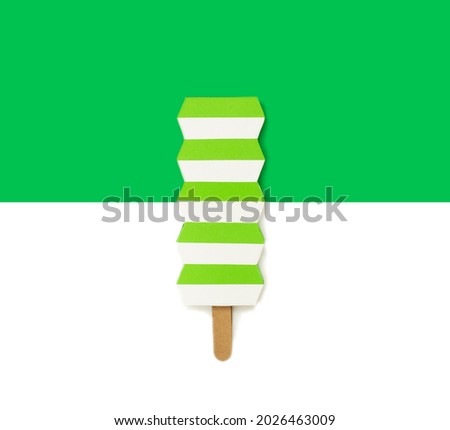 Creative paper ice cream on green background.