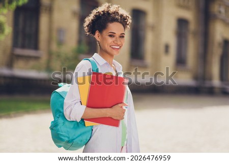 Profile side photo of young cheerful african woman happy positive smile study education university backpack outdoors