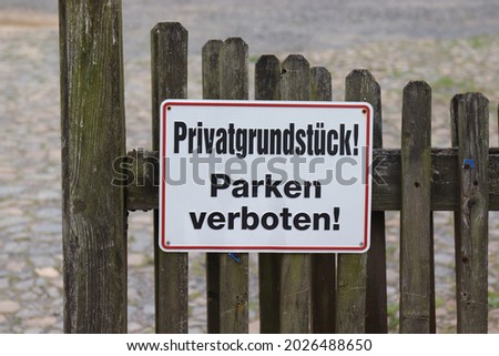 No parking sign on a German garden gate, "Privatgrundstück! Parken verboten!" means "Private property! No parking!"