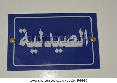 The pharmacy sign, An Arabic door sign on a door in a medical center, Hospital,  the translation of the sign ( The Pharmacy ), the wall sign is blue in color and the inscription is white colored 