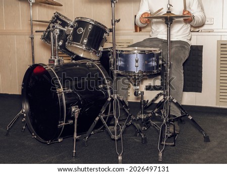 Man drum player hands with sticks and legs on pedal. Drummer.