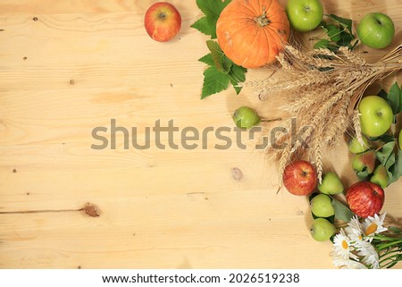 Thanksgiving background, harvest concept, autumn composition with fruits, natural berries, pumpkins, pears, apples, ears of wheat and rye, flowers on a wooden background with place for text,