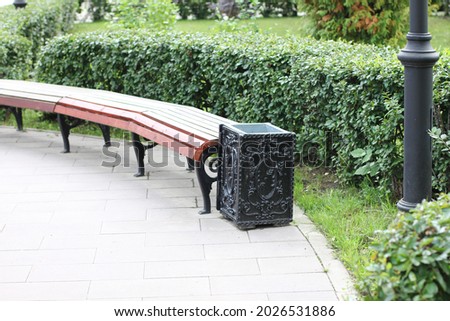 park bench on the sidewalk in the open air