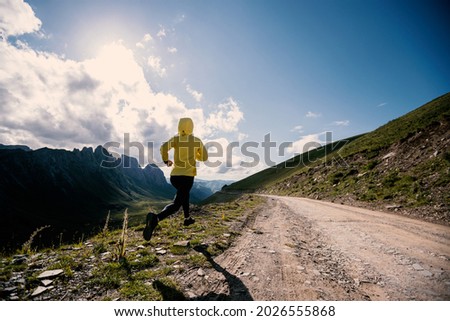 Young woman ultramarathon runner running at mountain top Royalty-Free Stock Photo #2026555868