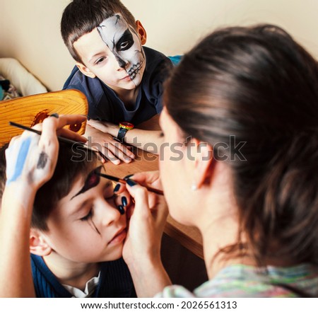little cute child making facepaint on birthday party, zombie Apocalypse facepainting, halloween preparing concept, lifestyle people Royalty-Free Stock Photo #2026561313