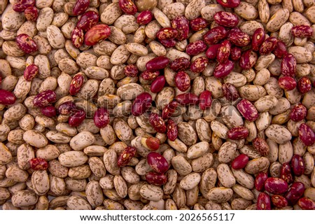 The photo shows red beans. The texture of the seeds is made in high resolution HD. The background of the beans is brown. The beans are red and pink