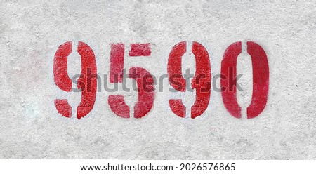 Red Number 9590 on the white wall. Spray paint. Number nine thousand five hundred ninety.