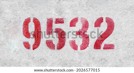 Red Number 9532 on the white wall. Spray paint. Number nine thousand five hundred thirty two.