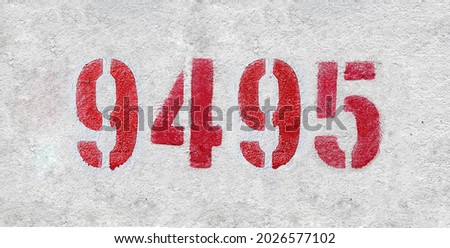 Red Number 9495 on the white wall. Spray paint. Number nine thousand four hundred ninety five.