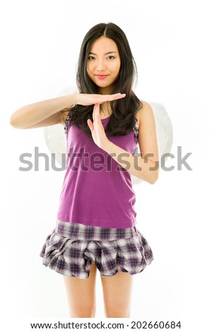 Asian young woman dressed up as an angel making time out signal with hands isolated on white background