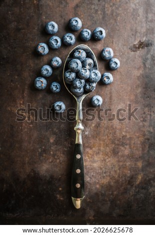 Blueberries on the spoon on rustic background. Shot from above. Selective focus.