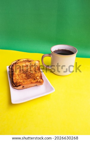 Toast On White Plate And Black Coffee Mug On Yellow And Green Paper Background. Toast And Black Coffee For Breakfast. Vertical Photo
