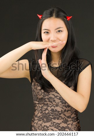 Asian young woman dressed up as an devil making time out signal with hands