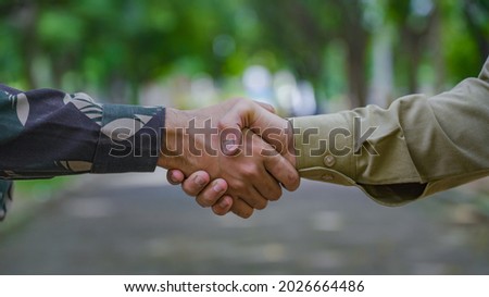 Indian in a uniform handshake with a police officer. 