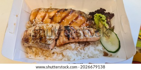 Café style grilled salmon teriyaki sauce bento set with salad in a take away packing box. Selective focus.