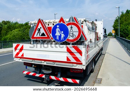 A worker's truck with roadsigns at a road construction site