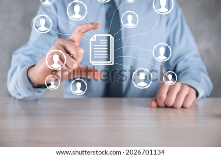 Man hold document and user icon.Corporate data management system DMS and document management system concept. Businessman click or publish on document connected with corporate users.