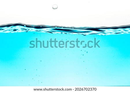 Blue water wave and bubbles, water waves cause bubbles and splatter in clear blue water. clean drinking water.