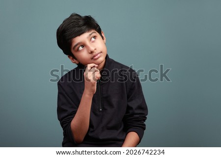 Little boy of Indian ethnicity looking up and thinking Royalty-Free Stock Photo #2026742234