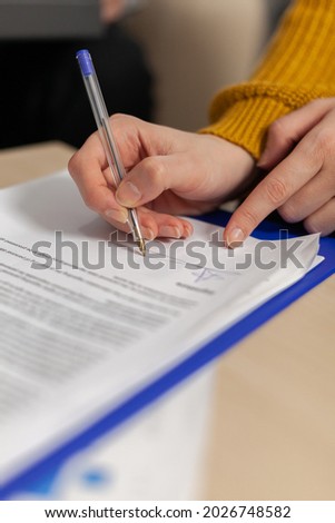 Businesswoman signing paper, partner hand puts signature on business document making employment contract agreement, taking bank loan insurance concept, patent certificate registration, close up view
