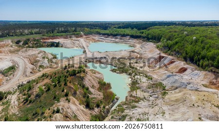 Small lakes with turquoise water in abandoned china clay quarry in spring day, aerial view

