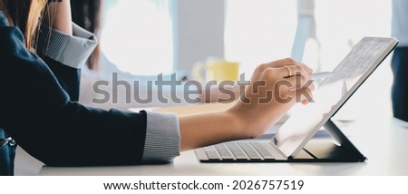 Close up hand of woman hand holding pen stylus writing on digital tablet computer