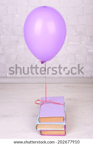 Color balloon with books on grey wall background