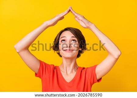 Photo of adorable satisfied person look interested up arms make home figure isolated on yellow color background