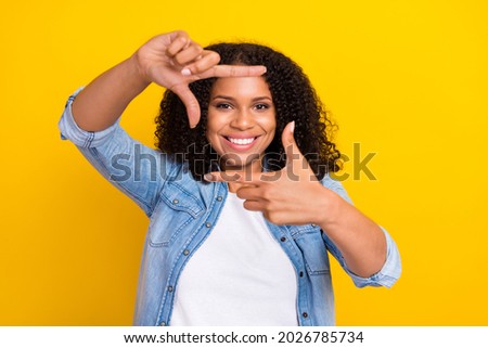 Photo of young happy afro american positive woman make fingers frame picture isolated on yellow color background