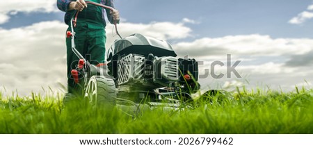 Man with lawn mower mowing the lawn
 Royalty-Free Stock Photo #2026799462