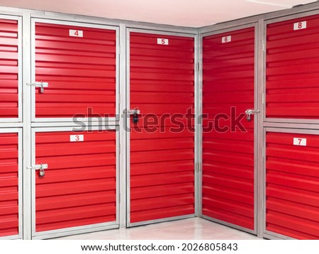 Storage corridor warehouse. Self storage facility, red metal doors with locks. Moving, organizing, storage concept.	 Royalty-Free Stock Photo #2026805843