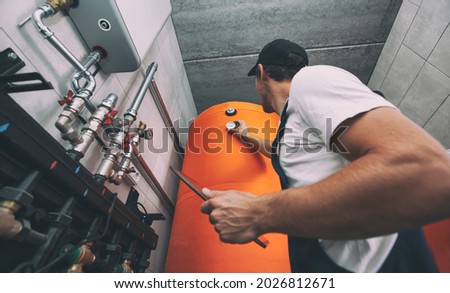 The technician checking the heating system in the boiler room with tablet in hand Royalty-Free Stock Photo #2026812671