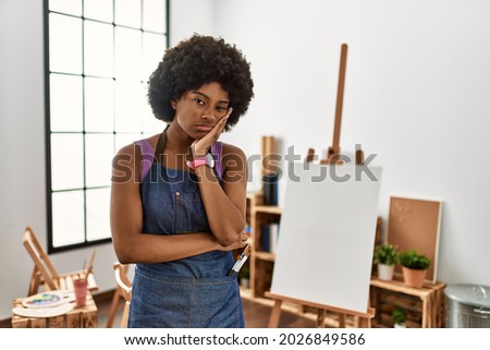 Young african american woman with afro hair at art studio thinking looking tired and bored with depression problems with crossed arms. 