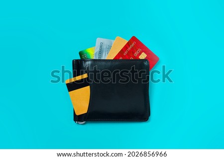 Leather wallet with credit and bank cards on a blue background. Plastic cards on the office desk.