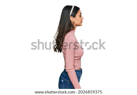 Young hispanic girl wearing casual clothes looking to side, relax profile pose with natural face with confident smile. 