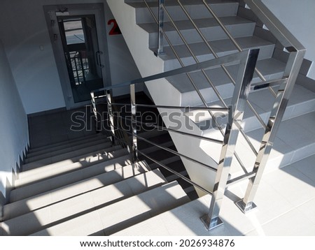 Modern stairs with metal railing in office building. Staircase with gray floor tiles. emergency exit in the shopping or business center . Royalty-Free Stock Photo #2026934876