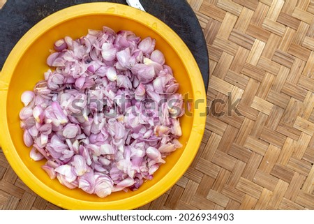 Sliced ​​red onions or shallots on a plate with a bamboo base. seen from above